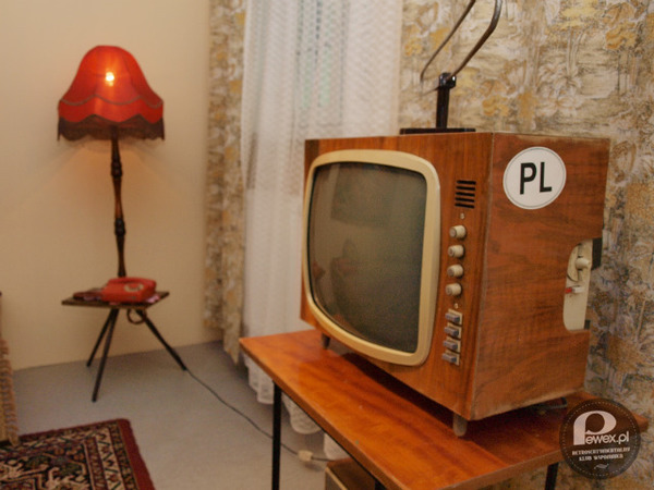 Typowe PRL-owskie wnętrze – PRL-owska lampa, dywan, telefon, telewizor, stolik itd 